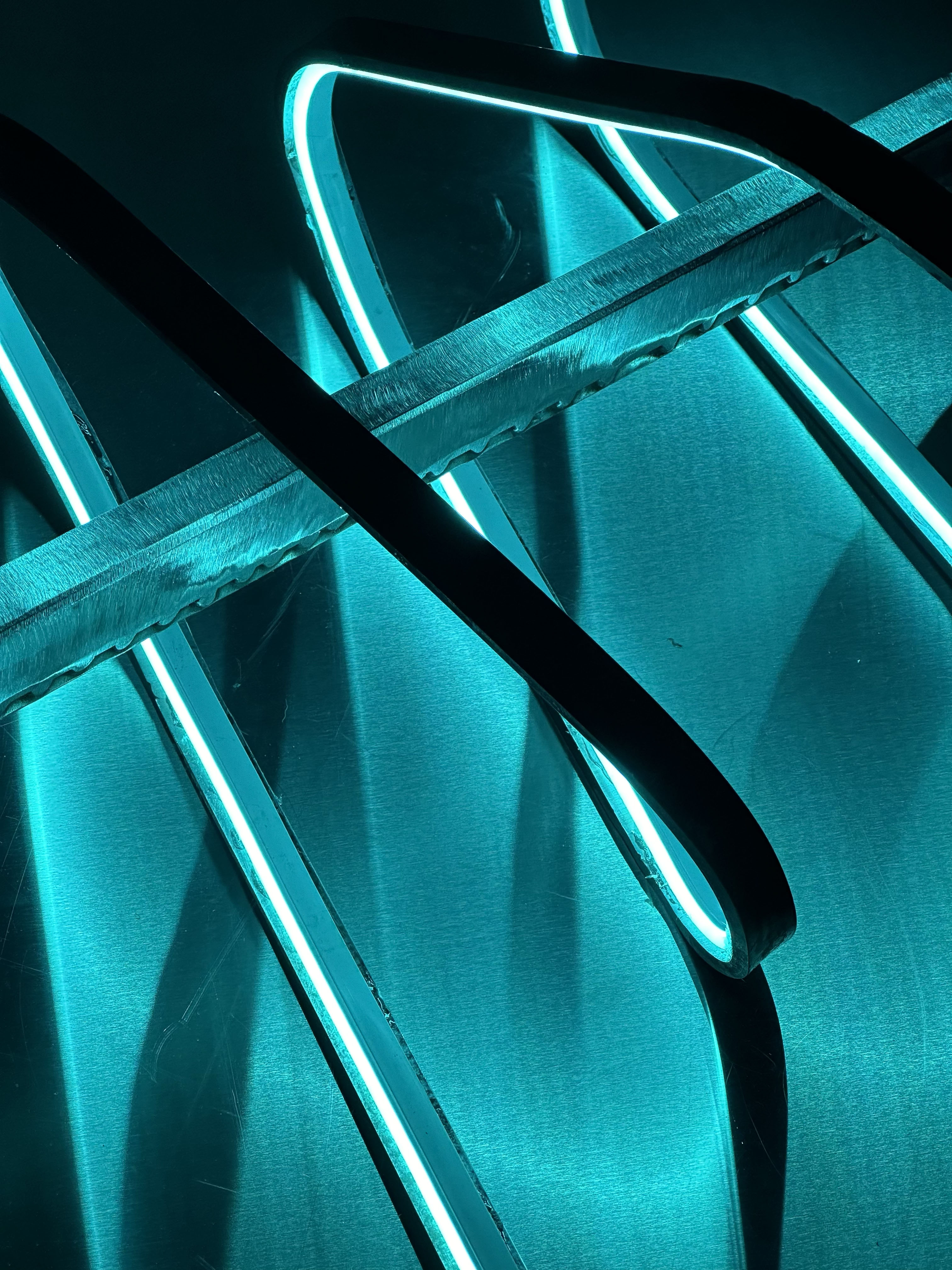 Close up details of steel form with cool blue neon LEDs.