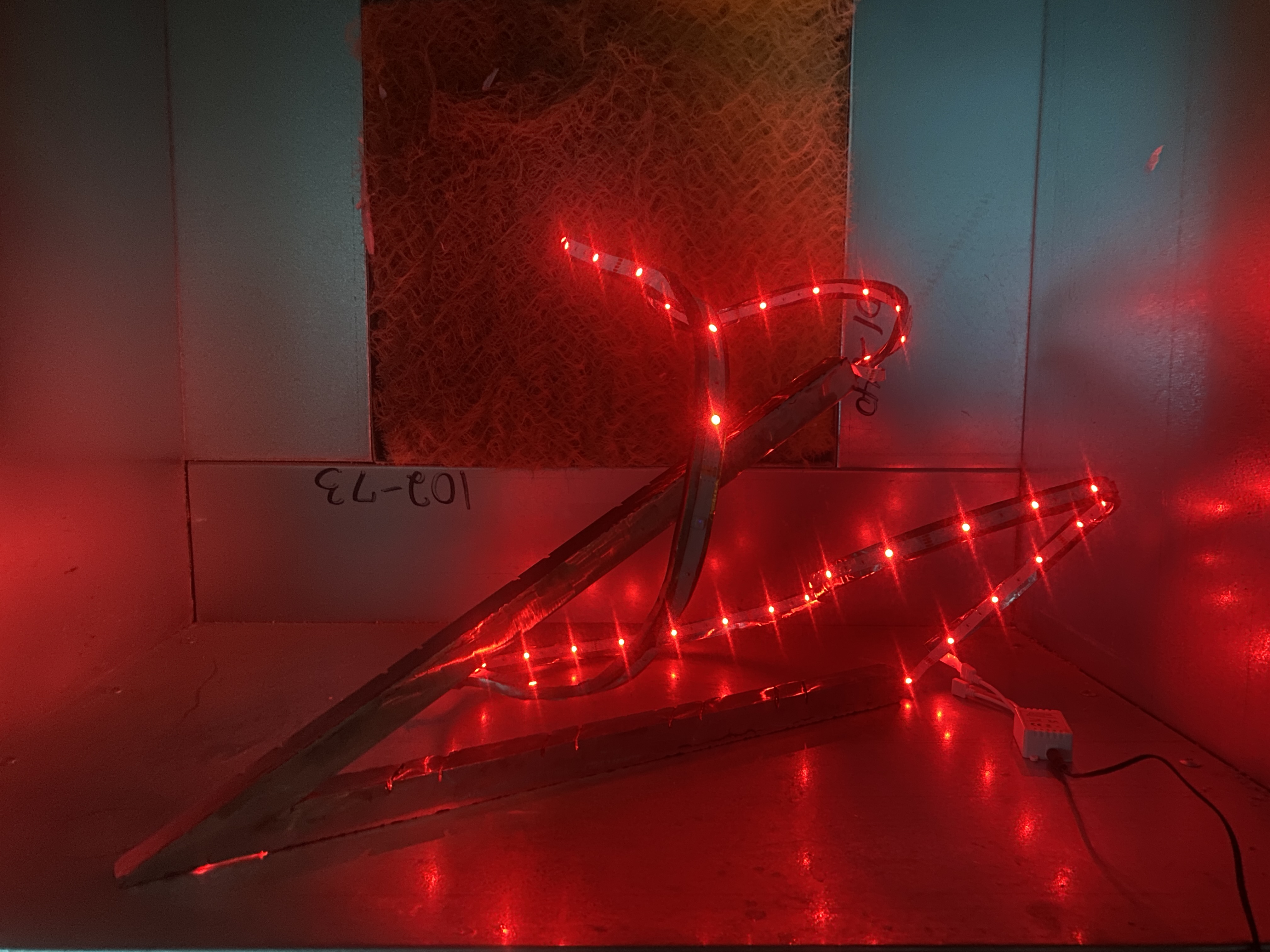 Close up details of abstract steel form with red LEDs.